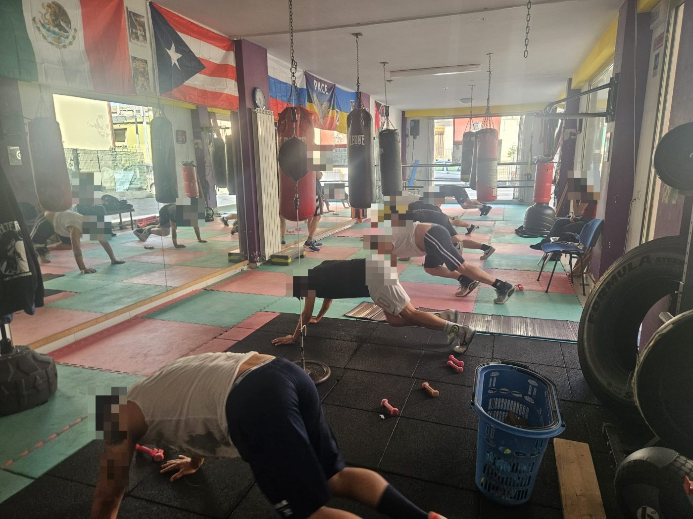 La Sala Boxe di Up Center durante un circuito: gli allievi lavorano a corpo libero sul tatami, fra i sacchi appesi